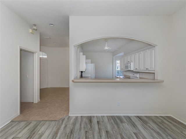 unfurnished living room with ceiling fan and light hardwood / wood-style flooring