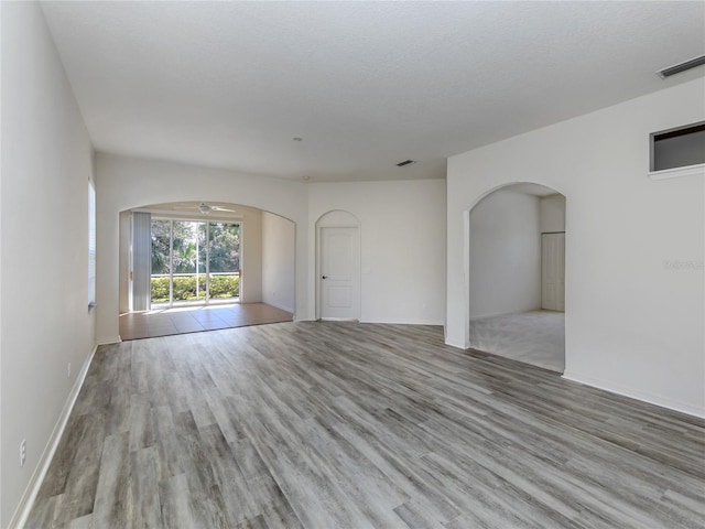 unfurnished room featuring light hardwood / wood-style flooring and a textured ceiling