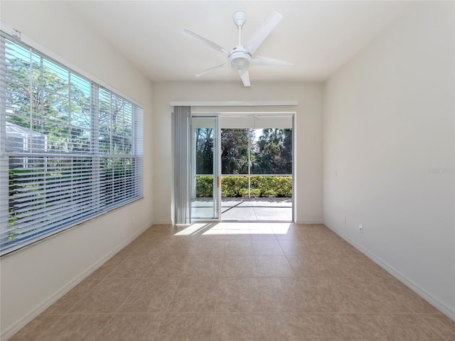 empty room with ceiling fan, light tile patterned floors, and plenty of natural light