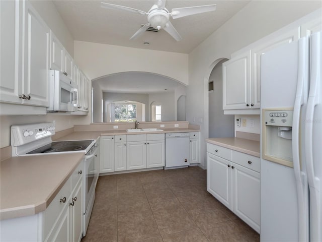 kitchen with tile patterned floors, white cabinetry, and white appliances