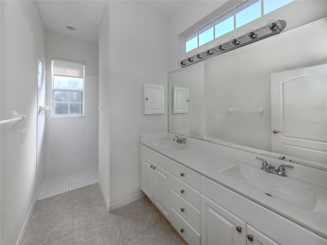 bathroom with vanity, a tile shower, tile patterned flooring, and plenty of natural light