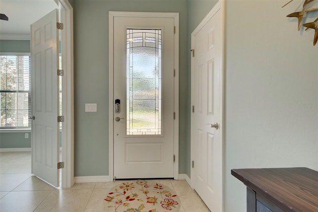 tiled foyer entrance featuring crown molding