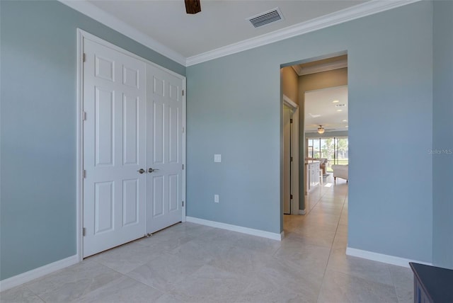 unfurnished bedroom featuring ceiling fan, a closet, and crown molding