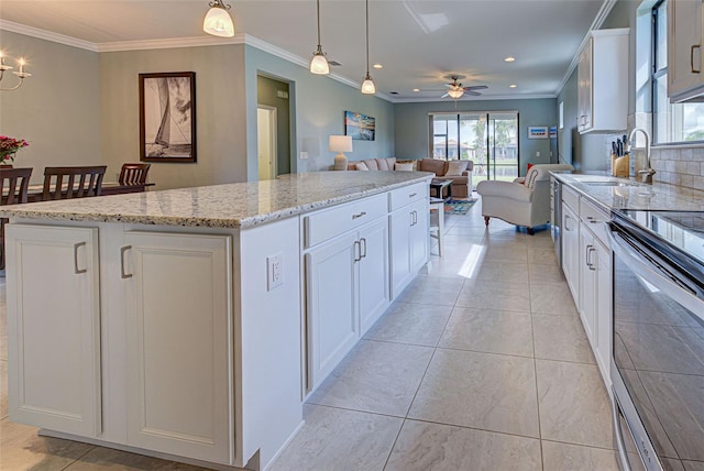 kitchen featuring decorative light fixtures, a center island, sink, and white cabinets