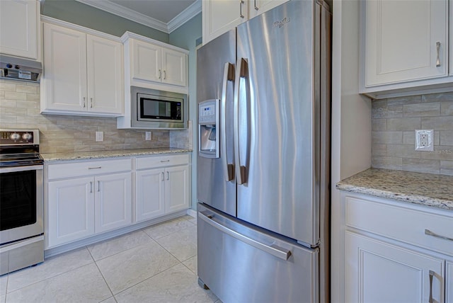 kitchen with decorative backsplash, white cabinets, light stone countertops, light tile patterned floors, and stainless steel appliances