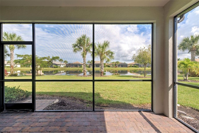 unfurnished sunroom featuring a water view