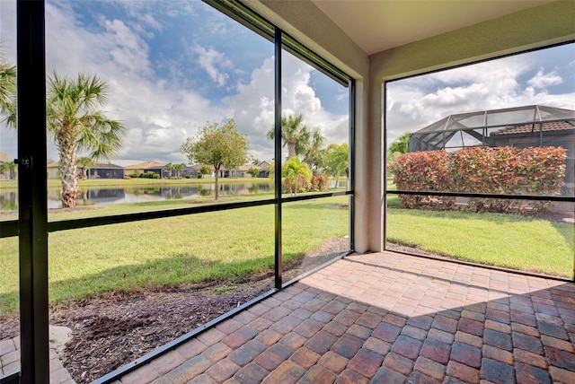 unfurnished sunroom featuring a water view