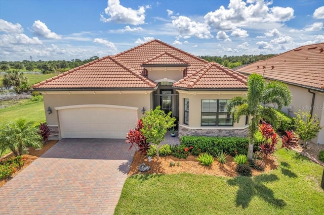 mediterranean / spanish-style house featuring a front yard and a garage