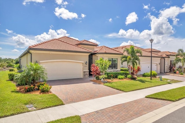 mediterranean / spanish home featuring a front yard and a garage