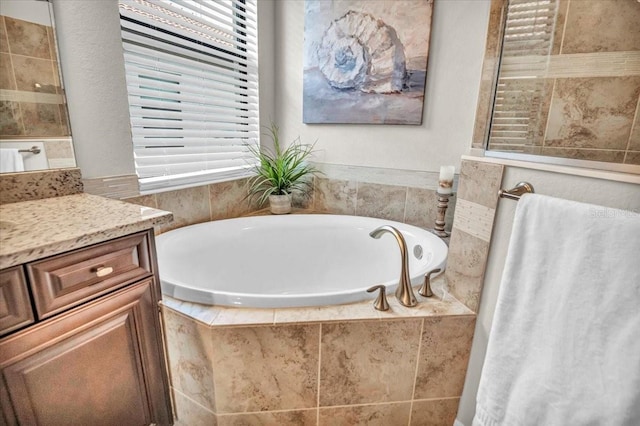 bathroom with vanity and a relaxing tiled tub