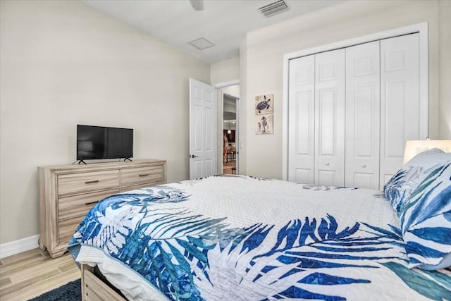 bedroom with light hardwood / wood-style flooring, a closet, and ceiling fan