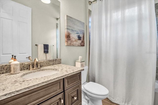 bathroom featuring vanity, hardwood / wood-style floors, a shower with curtain, and toilet