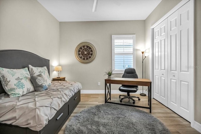 bedroom with a closet, light wood-type flooring, and ceiling fan