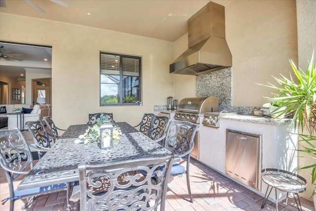 view of patio featuring area for grilling, ceiling fan, and exterior kitchen