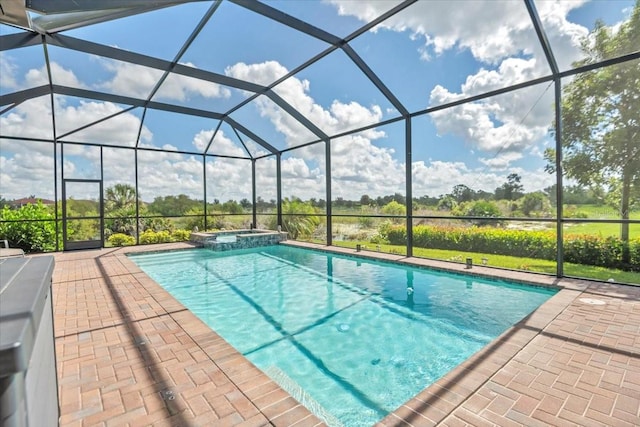 view of swimming pool with an in ground hot tub, a patio, and glass enclosure