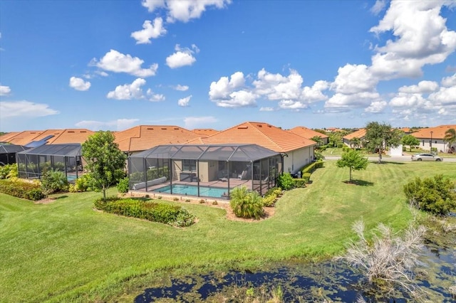 back of property with a lawn and a lanai