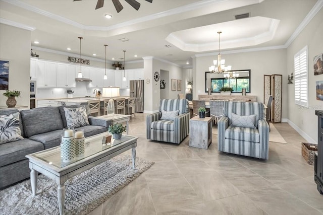 living room featuring ornamental molding, a tray ceiling, ceiling fan with notable chandelier, and light tile patterned floors