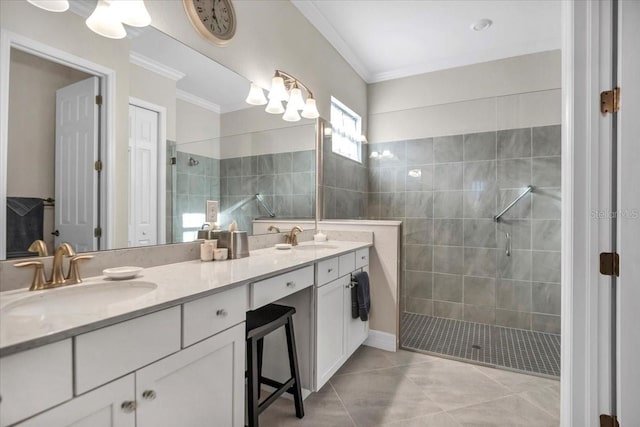 bathroom featuring vanity, ornamental molding, a tile shower, and tile patterned floors