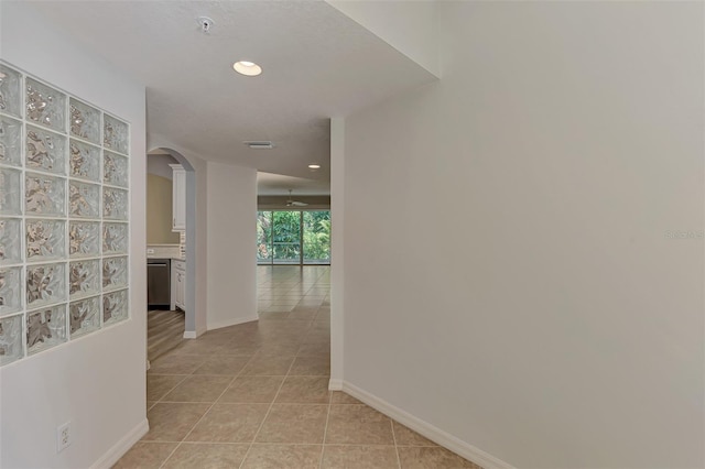 hall with light tile patterned floors