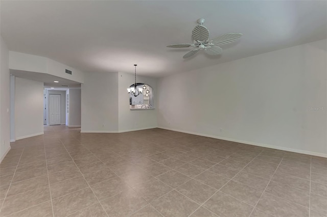 empty room with ceiling fan with notable chandelier and light tile patterned flooring