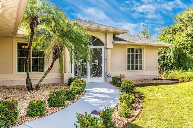 doorway to property with a lawn