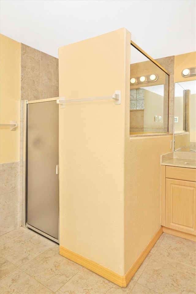 bathroom featuring walk in shower, vanity, and tile patterned floors