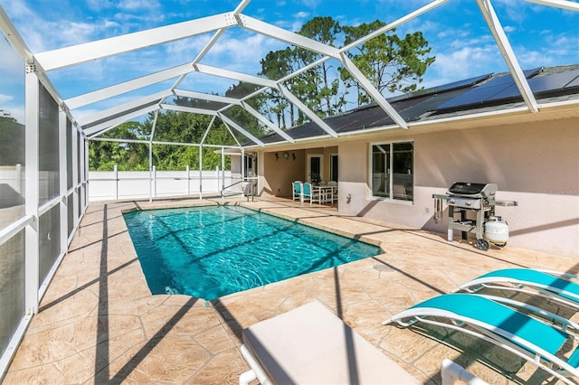 view of pool with glass enclosure, a patio area, and a grill