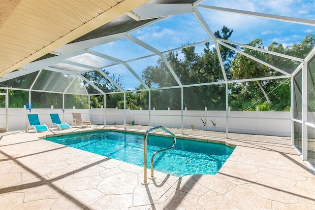 view of swimming pool featuring a lanai and a patio area