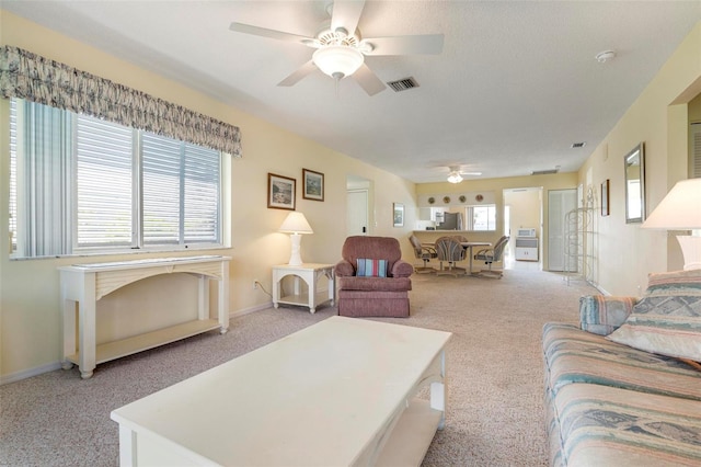 living room with ceiling fan, light colored carpet, and a healthy amount of sunlight