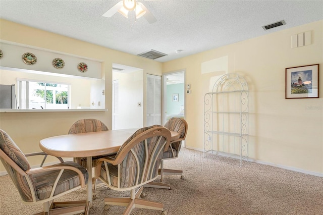 carpeted dining area featuring a textured ceiling and ceiling fan