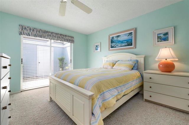 carpeted bedroom featuring access to outside, a textured ceiling, and ceiling fan