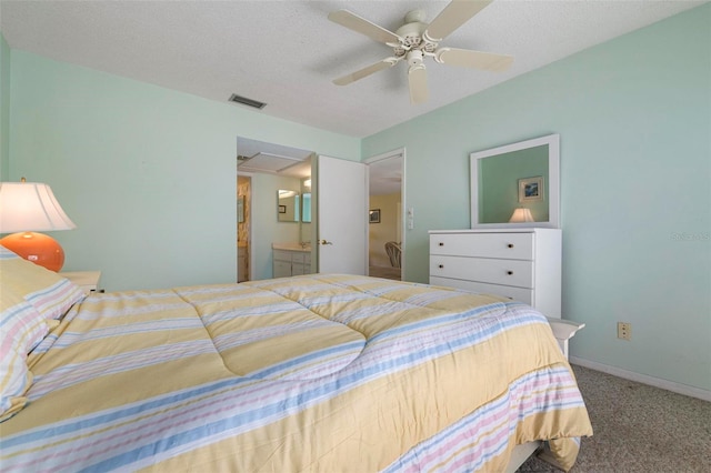 carpeted bedroom featuring connected bathroom, ceiling fan, and a textured ceiling