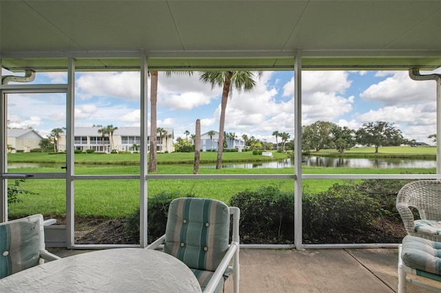 sunroom featuring a healthy amount of sunlight and a water view