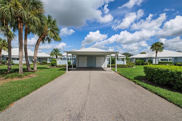 ranch-style house featuring a carport and a front lawn