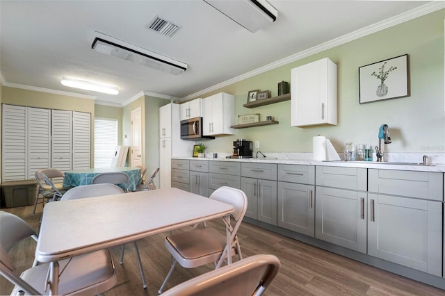 kitchen featuring sink, gray cabinetry, white cabinetry, crown molding, and dark hardwood / wood-style flooring