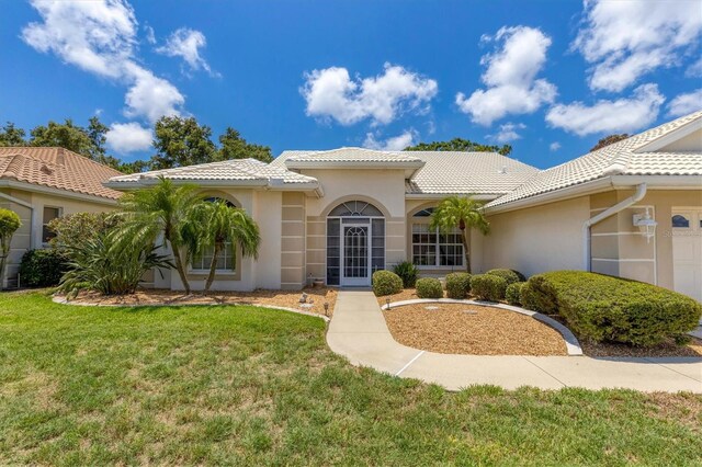 mediterranean / spanish-style home with a front lawn and a garage