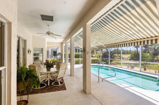 view of pool with glass enclosure, ceiling fan, and a patio area