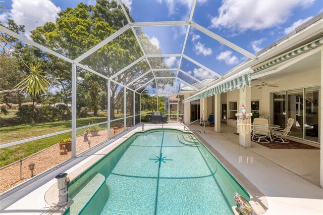 view of pool with ceiling fan, a lanai, and a patio area