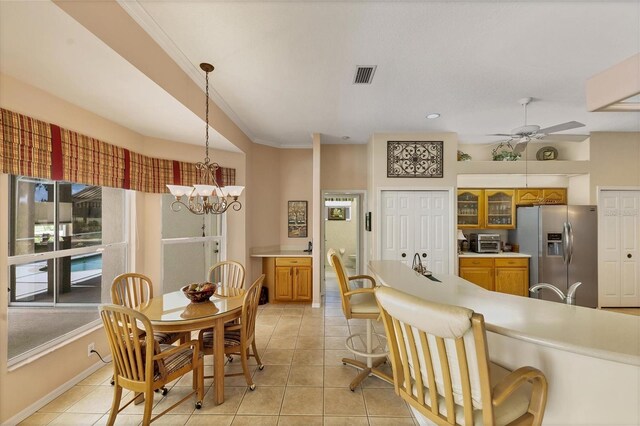 kitchen with ceiling fan with notable chandelier, stainless steel refrigerator with ice dispenser, light tile patterned flooring, and ornamental molding