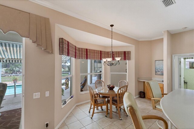 tiled dining room with ornamental molding and a chandelier