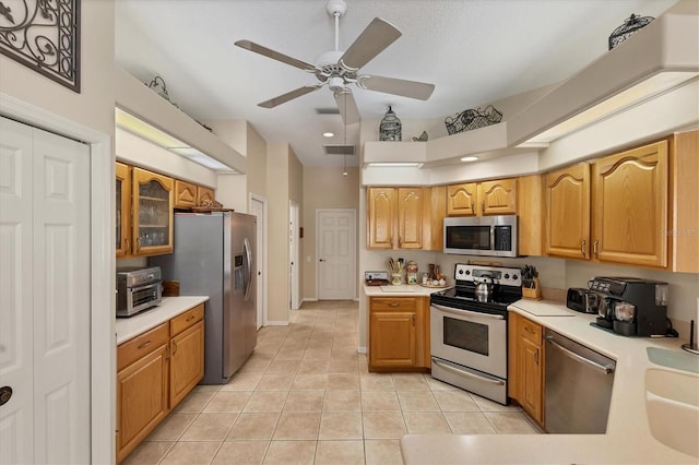 kitchen with stainless steel appliances, ceiling fan, light tile patterned floors, and sink