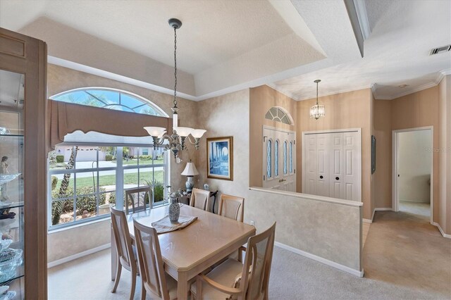 carpeted dining area with a textured ceiling, a raised ceiling, and a chandelier