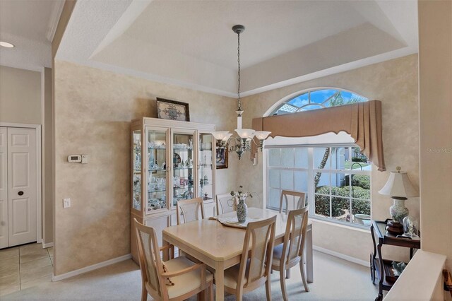 dining area featuring a healthy amount of sunlight, light carpet, and a raised ceiling