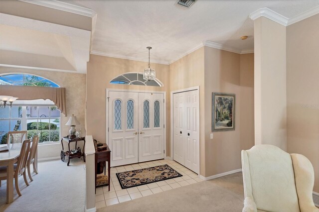 foyer entrance featuring light carpet, a chandelier, and crown molding