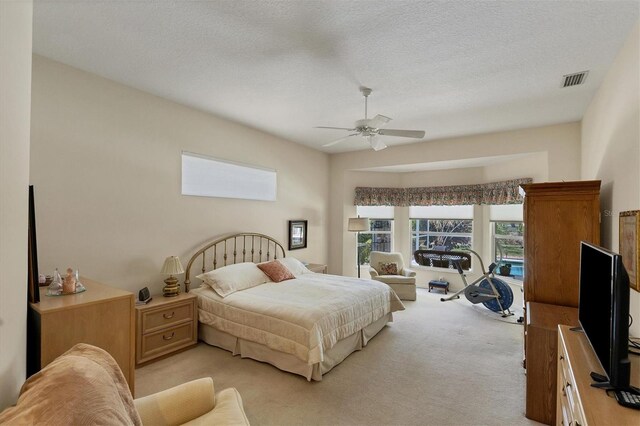 carpeted bedroom with a textured ceiling and ceiling fan