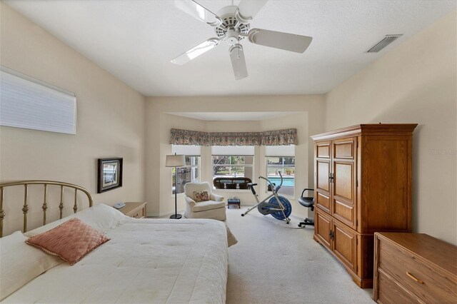 carpeted bedroom featuring a textured ceiling and ceiling fan