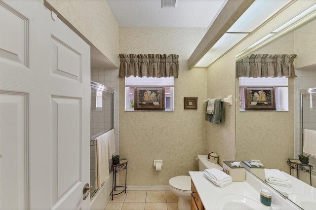 bathroom with vanity, toilet, tile patterned floors, and a shower with shower door