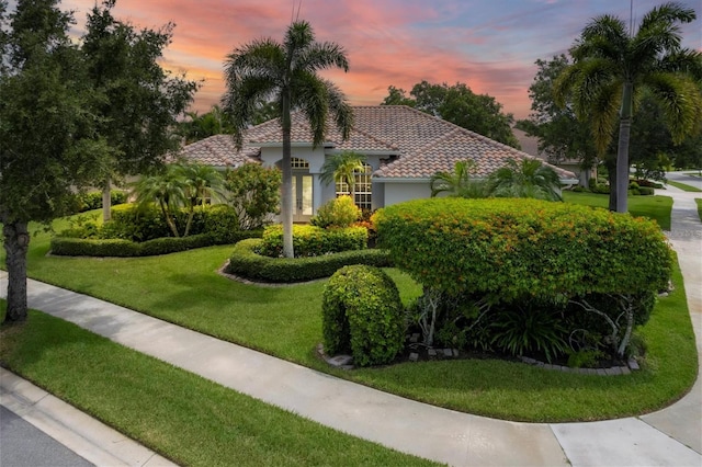 mediterranean / spanish home with a lawn