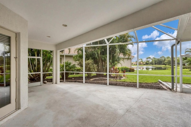 unfurnished sunroom featuring a water view