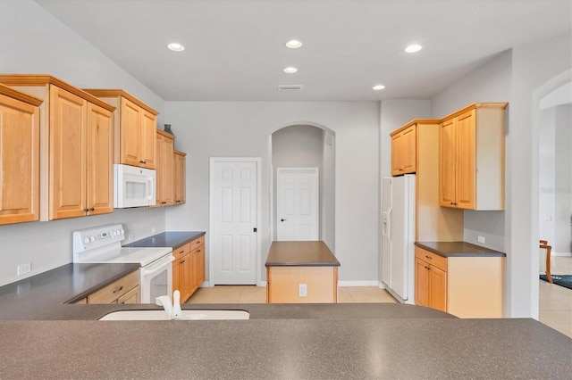 kitchen with light tile patterned flooring, white appliances, a kitchen island, light brown cabinetry, and sink